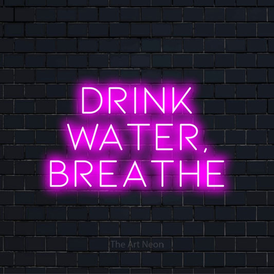"Drink Water, Breathe" LED neon sign on a black brick wall