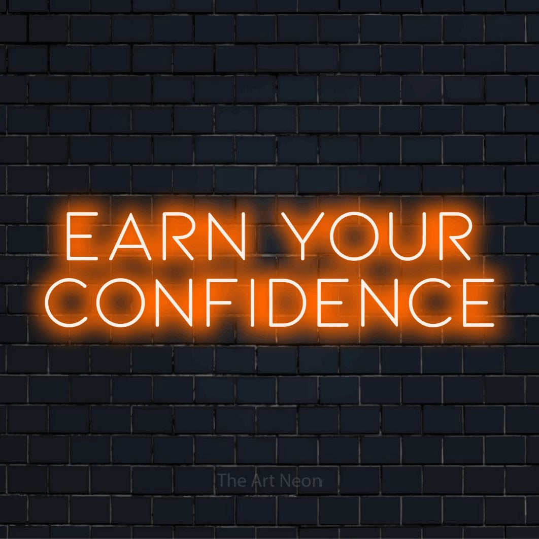 "Earn Your Confidence" text design with neon effect on a black brick wall