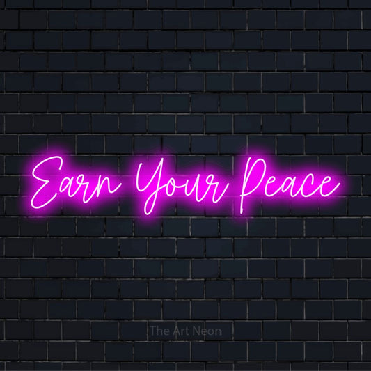 "Earn Your Peace" script-style LED neon sign on a black brick wall