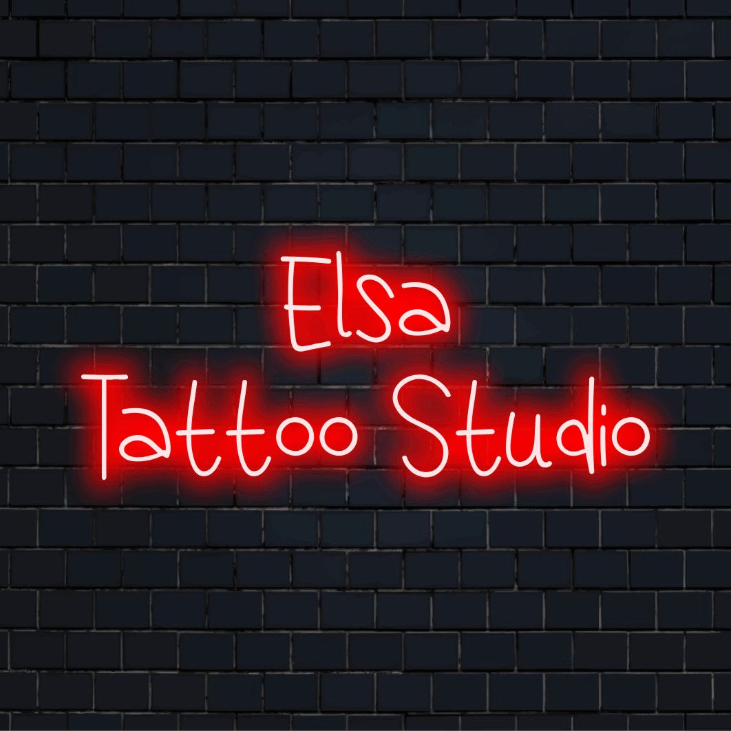 Elsa Tattoo Studio Custom Name Neon Sign, soft neon glow against brick backdrop