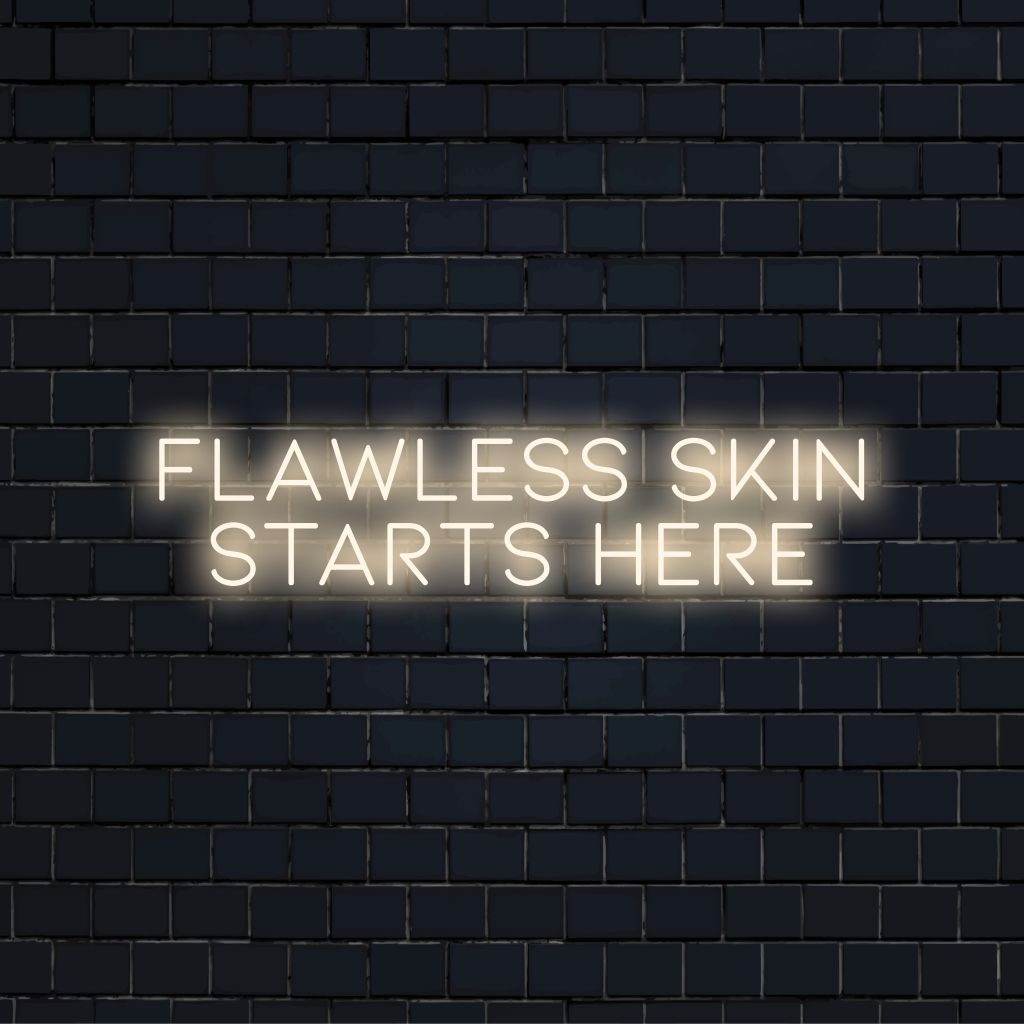 Flawless Skin Starts Here Neon Sign, soft neon glow on dark brick wall