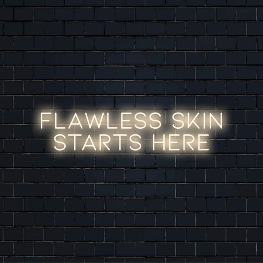 Flawless Skin Starts Here Neon Sign, soft neon glow on dark brick wall