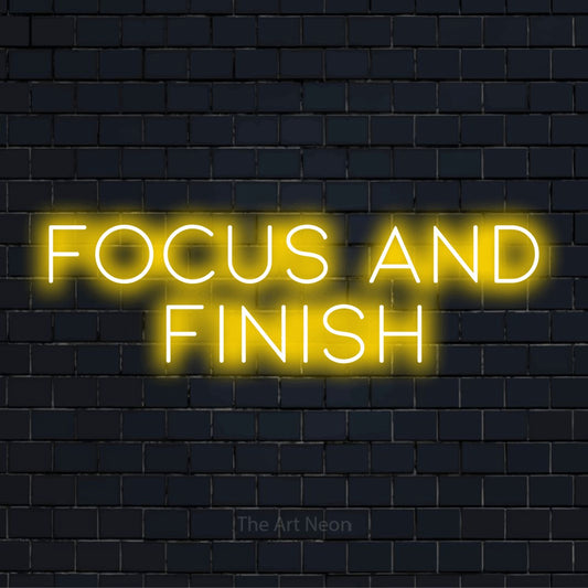 "Focus And Finish" LED neon sign on a black brick wall