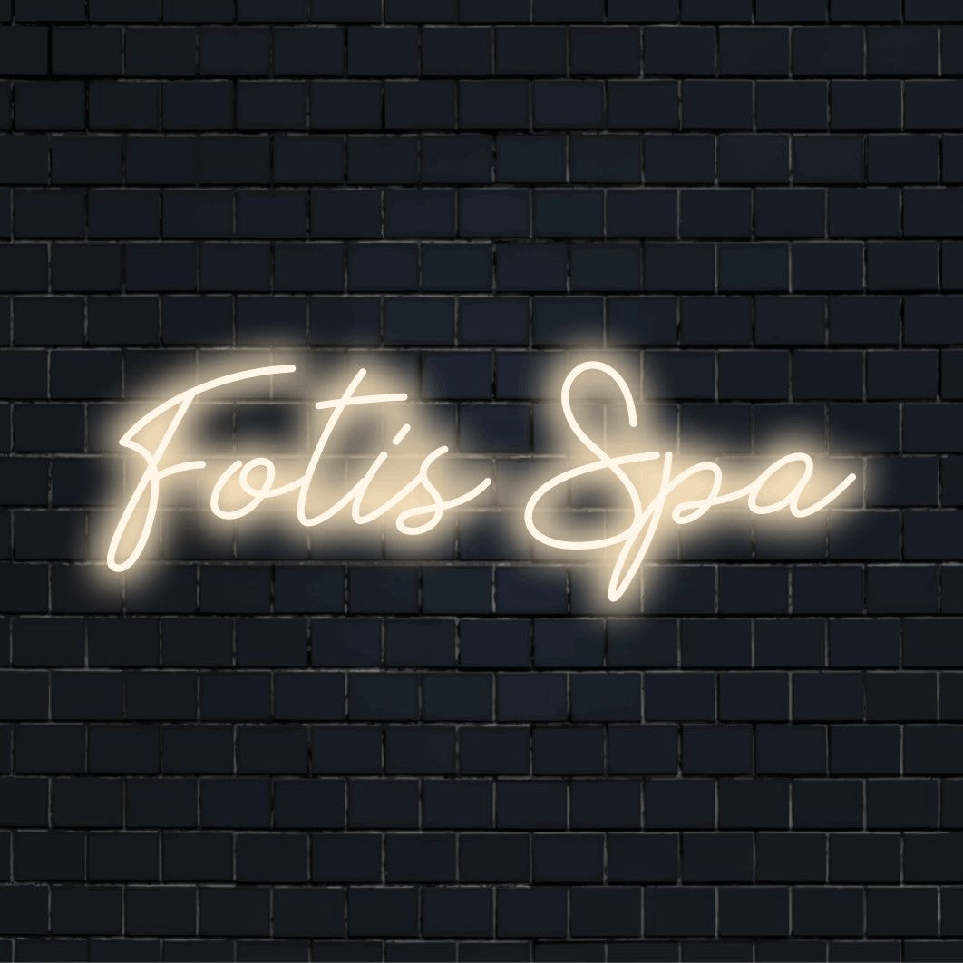 Fotis Spa Custom Name Neon Sign, neon text light against brick backdrop