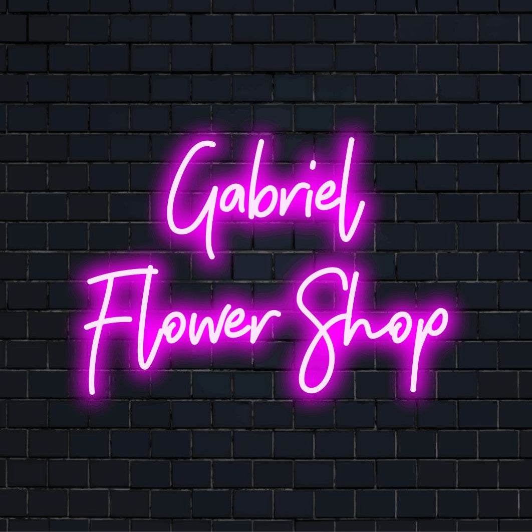 Gabriel Flower Shop Custom Name Neon Sign, bright neon lettering on dark brick background
