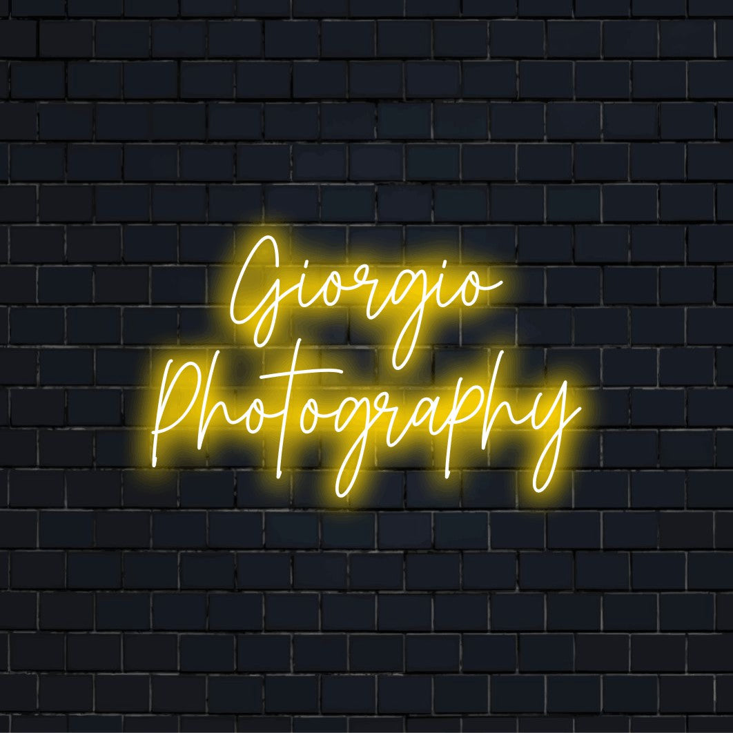 Giorgio Photography Custom Name Neon Sign, bright neon lettering on dark brick background