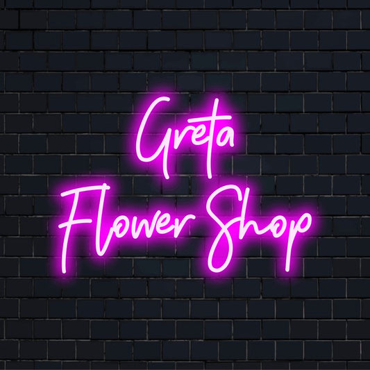 Greta Flower Shop Personalized LED Neon Sign, bright neon lettering on dark brick wall