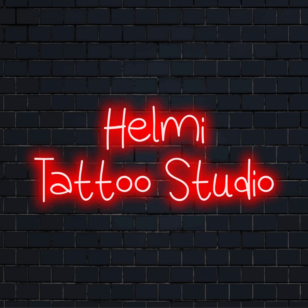 Helmi Tattoo Studio Personalized Neon Light with glowing lettering against brick backdrop