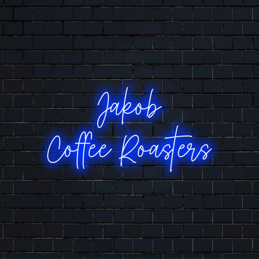 Jakob Coffee Roasters Personalized Neon Light with soft neon glow against brick backdrop