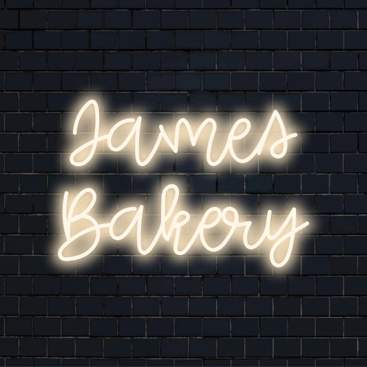 James Bakery Personalized LED Neon Sign, glowing neon text against black brick wall