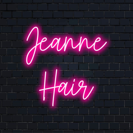 Jeanne Hair Personalized Neon Light with neon text light against brick backdrop