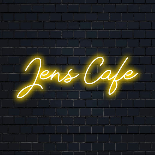 Jens Cafe Personalized Neon Light with glowing neon text against black brick wall