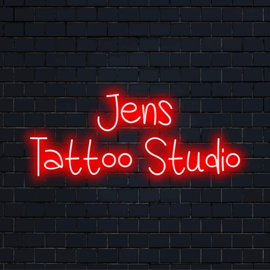 Jens Tattoo Studio Personalized LED Neon Sign, bright neon glow against black brick wall