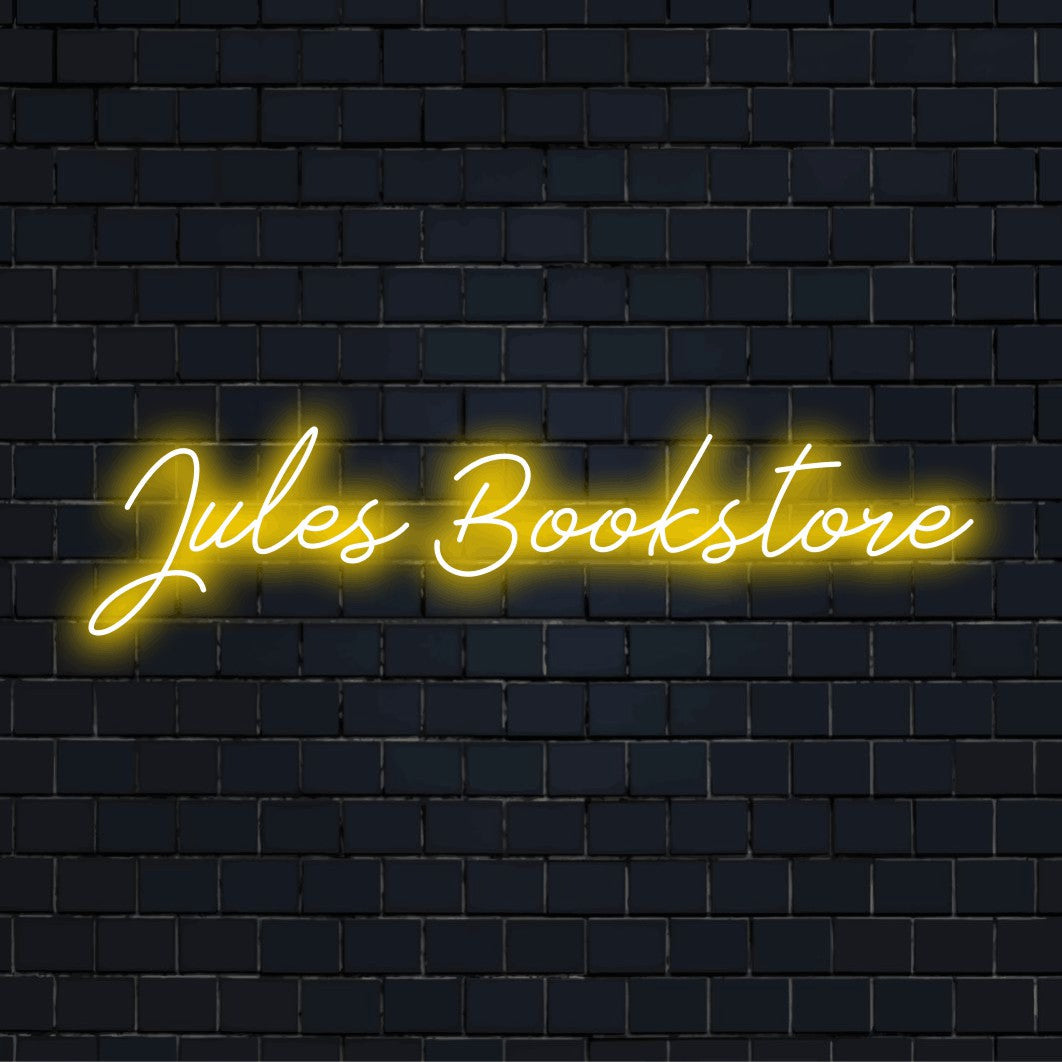 Jules Bookstore Personalized Neon Light with bright neon glow on dark brick wall