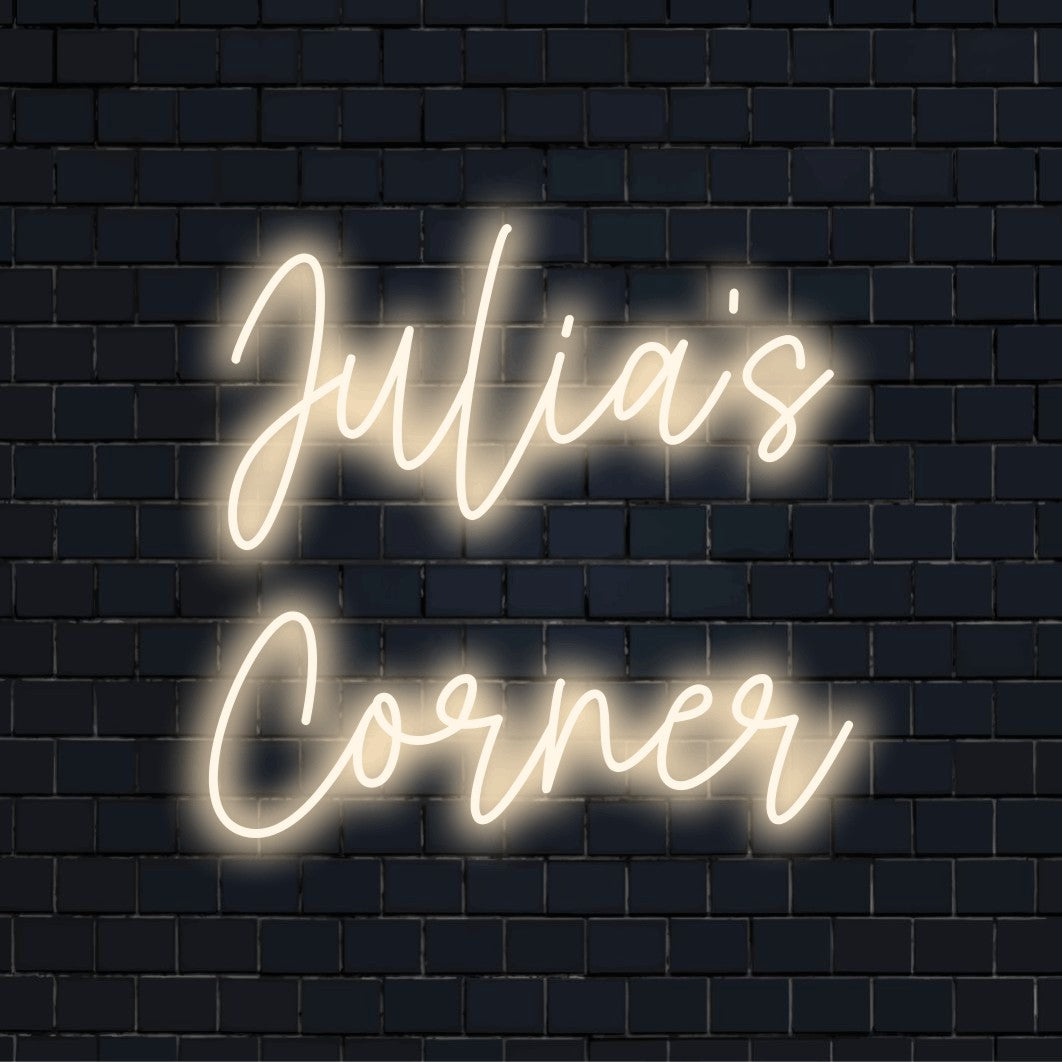 Julia_s Corner Custom Name Neon Sign, glowing wall decor against black brick wall