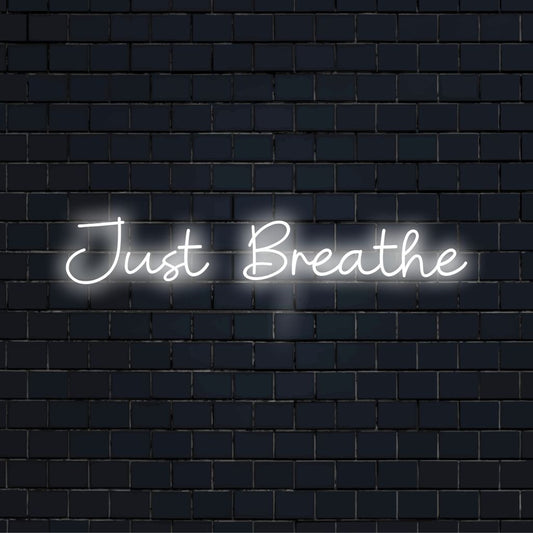 Just Breathe Neon Sign, glowing lettering against brick backdrop