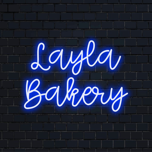 Layla Bakery Personalized Neon Light with bright neon lettering against black brick wall