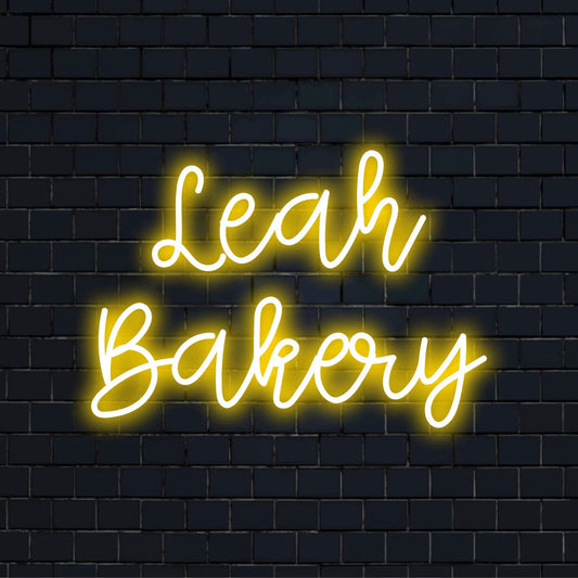 Leah Bakery Personalized LED Neon Sign, glowing wall decor against black brick wall