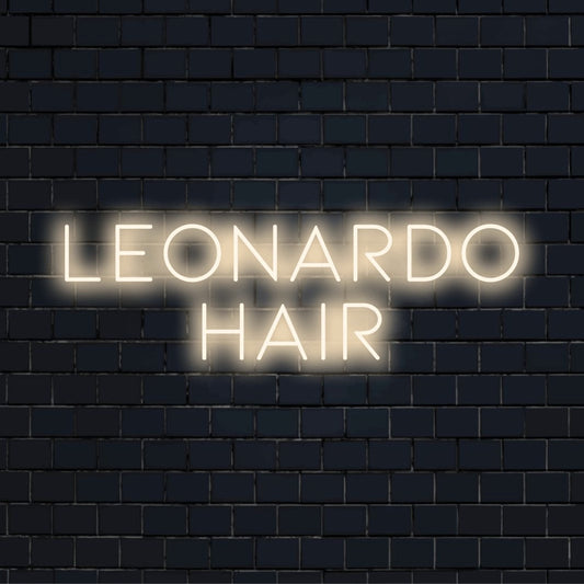 Leonardo Hair Personalized Neon Light with glowing neon text against black brick wall