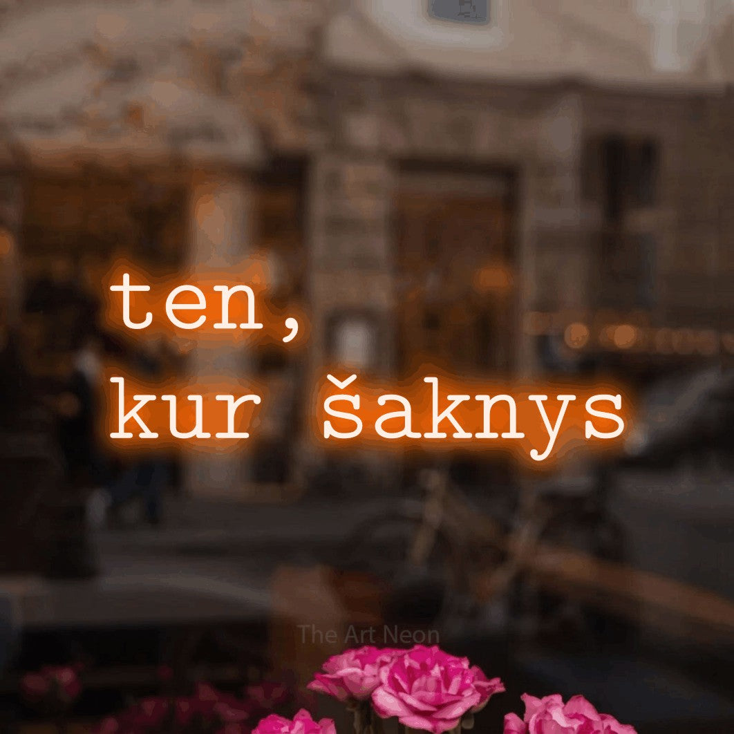 LED neon sign reading “ten, kur šaknys”, arranged in two lines.
