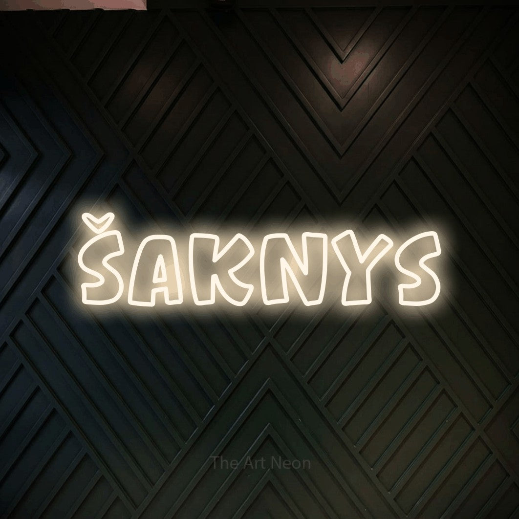 LED neon sign reading “Šaknys”, arranged in a single line.