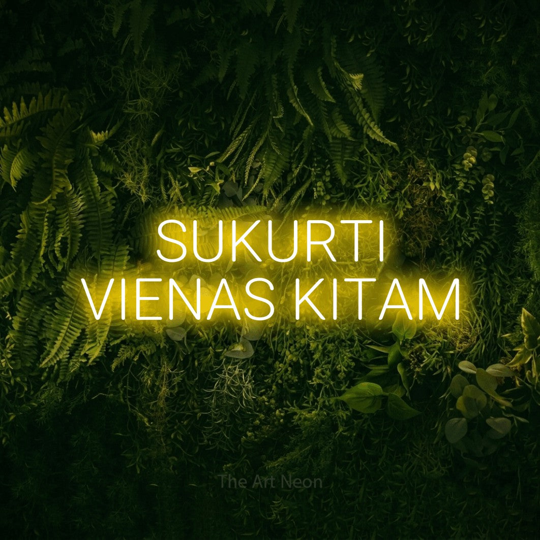 LED neon sign reading “SUKURTI VIENAS KITAM”, arranged in two lines.