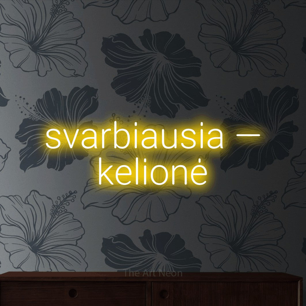 LED neon sign reading “svarbiausia — kelionė”, arranged in two lines.