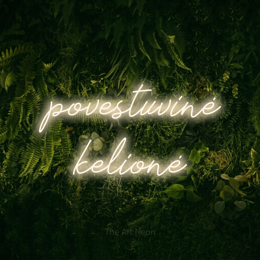 LED neon sign reading “povestuvinė kelionė”, arranged in two lines.