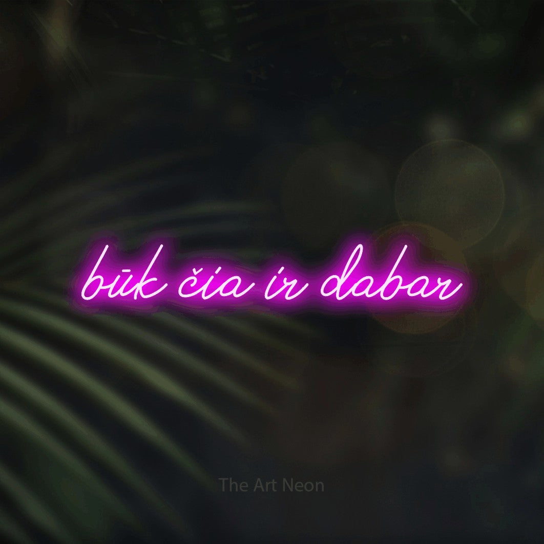 LED neon sign reading “būk čia ir dabar”, arranged in a single line.
