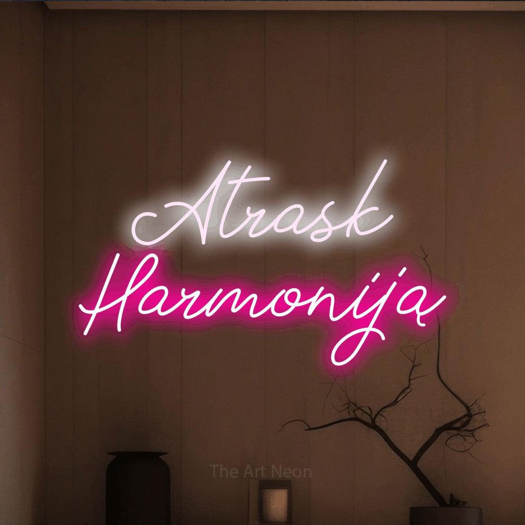 LED neon sign reading “Atrask Harmoniją”, arranged in two lines.