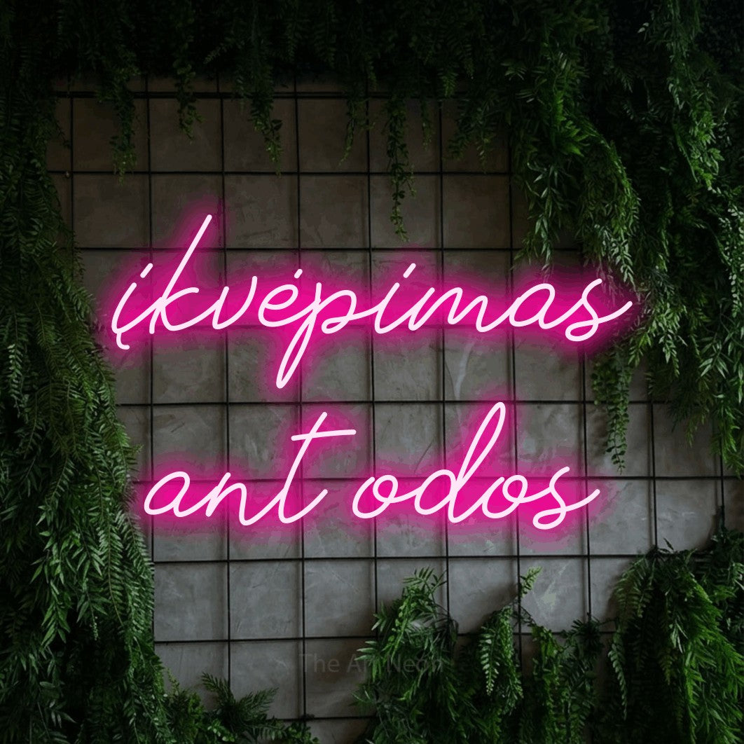 LED neon sign reading “įkvėpimas ant odos”, arranged in two lines.