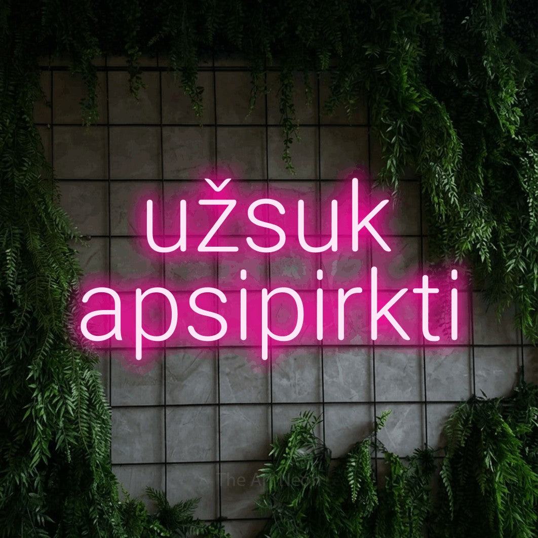 LED neon sign reading “užsuk apsipirkti”, arranged in two lines.