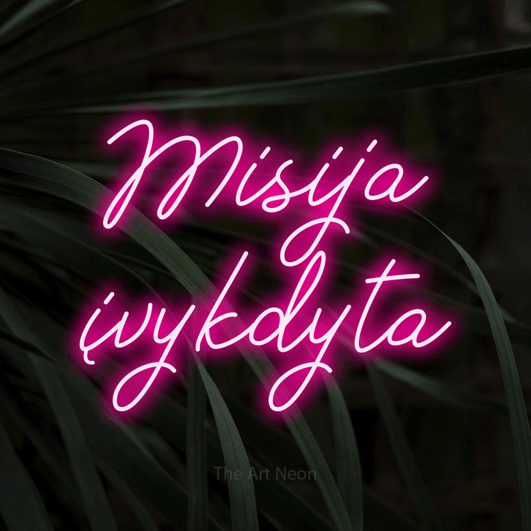 LED neon sign reading “Misija įvykdyta”, arranged in two lines.