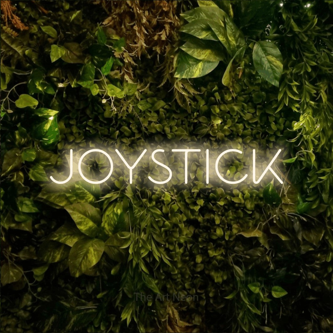 LED neon sign reading “JOYSTICK”, arranged in a single line.