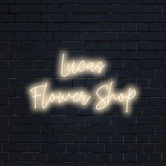 Lucas Flower Shop Custom Name Neon Sign, glowing wall decor against black brick wall
