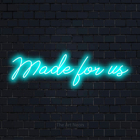 "Made For Us" neon text design on a black brick wall