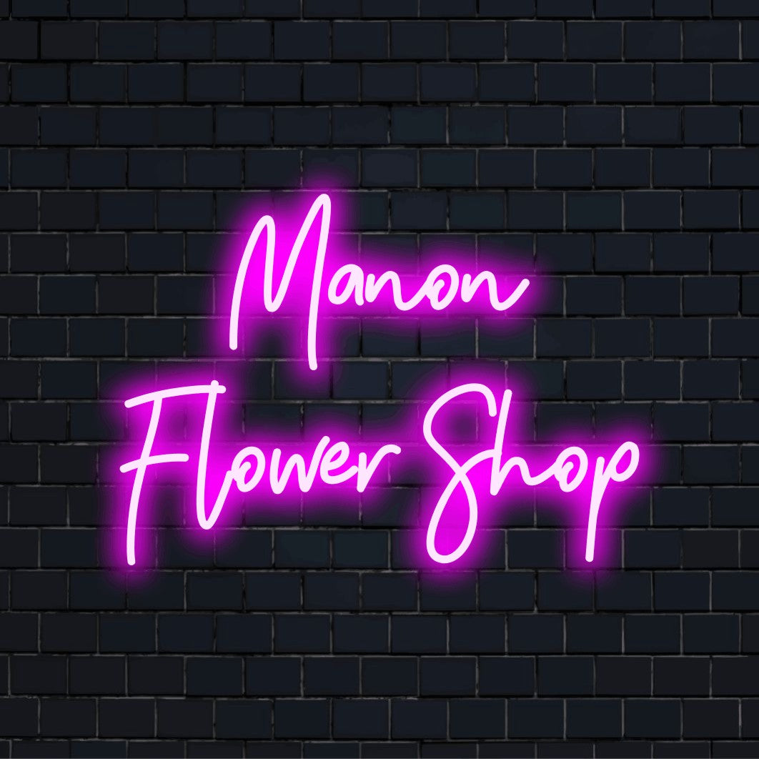 Manon Flower Shop Custom Name Neon Sign, bright neon glow on black brick background
