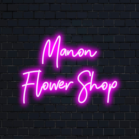 Manon Flower Shop Custom Name Neon Sign, bright neon glow on black brick background