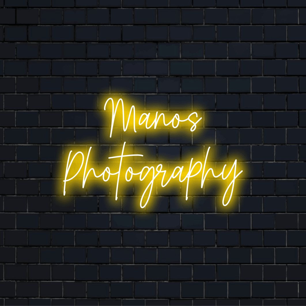 Manos Photography Custom Name Neon Sign, glowing lettering against brick backdrop