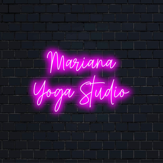 Mariana Yoga Studio Custom Name Neon Sign, bright neon glow against black brick wall