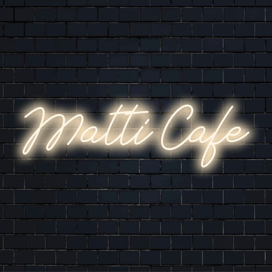 Matti Cafe Custom Name Neon Sign, neon text light against black brick wall