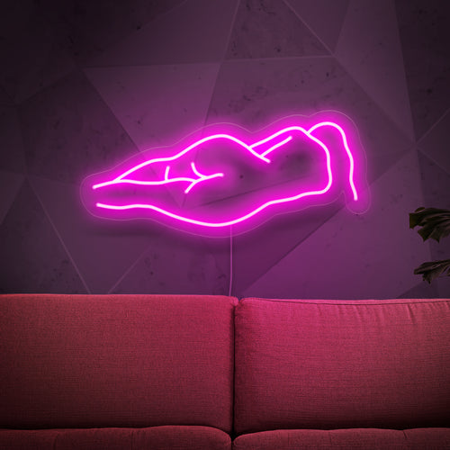 L'insegna al neon raffigurante un corpo di donna nuda è un'aggiunta artistica all'arredamento, che emana una luce sensuale e accattivante.