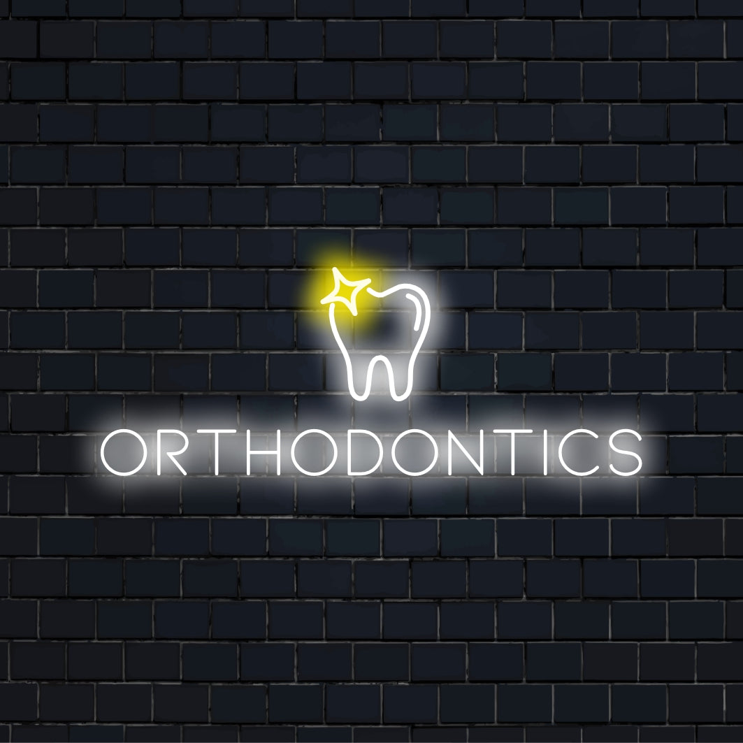 Orthodontics Neon Sign, glowing neon text against black brick wall