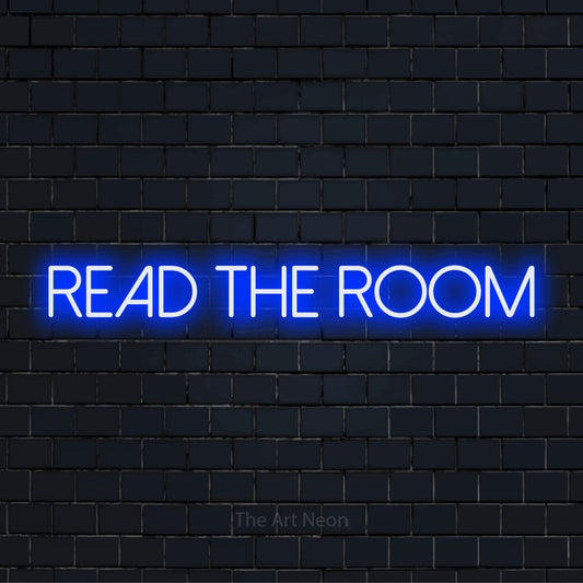 "Read The Room" glowing LED neon sign on a black brick wall