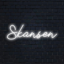 Skansen Neon Light with glowing lettering against brick backdrop