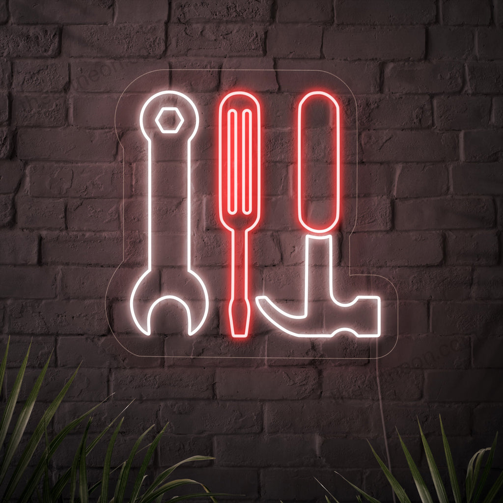 A striking neon sign featuring the symbols of a spanner, hammer, and screwdriver.