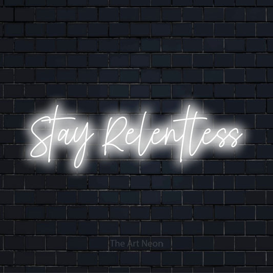 "Stay Relentless" script-style LED neon sign on a black brick wall