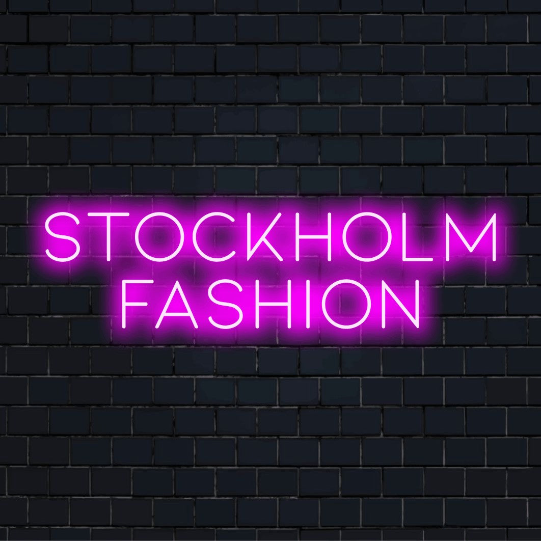 Stockholm Fashion Neon Light with soft neon glow on dark brick wall