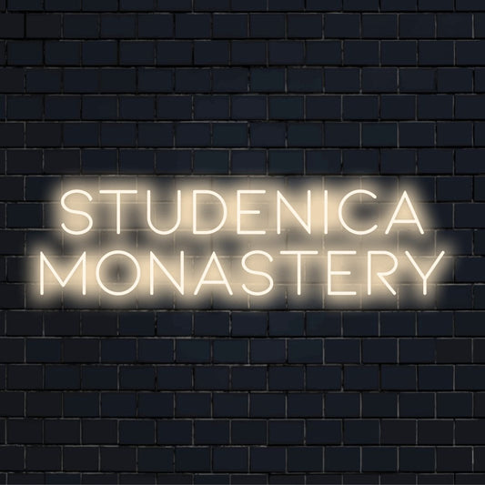 Studenica Monastery LED Neon Sign, bright neon lettering on dark brick background