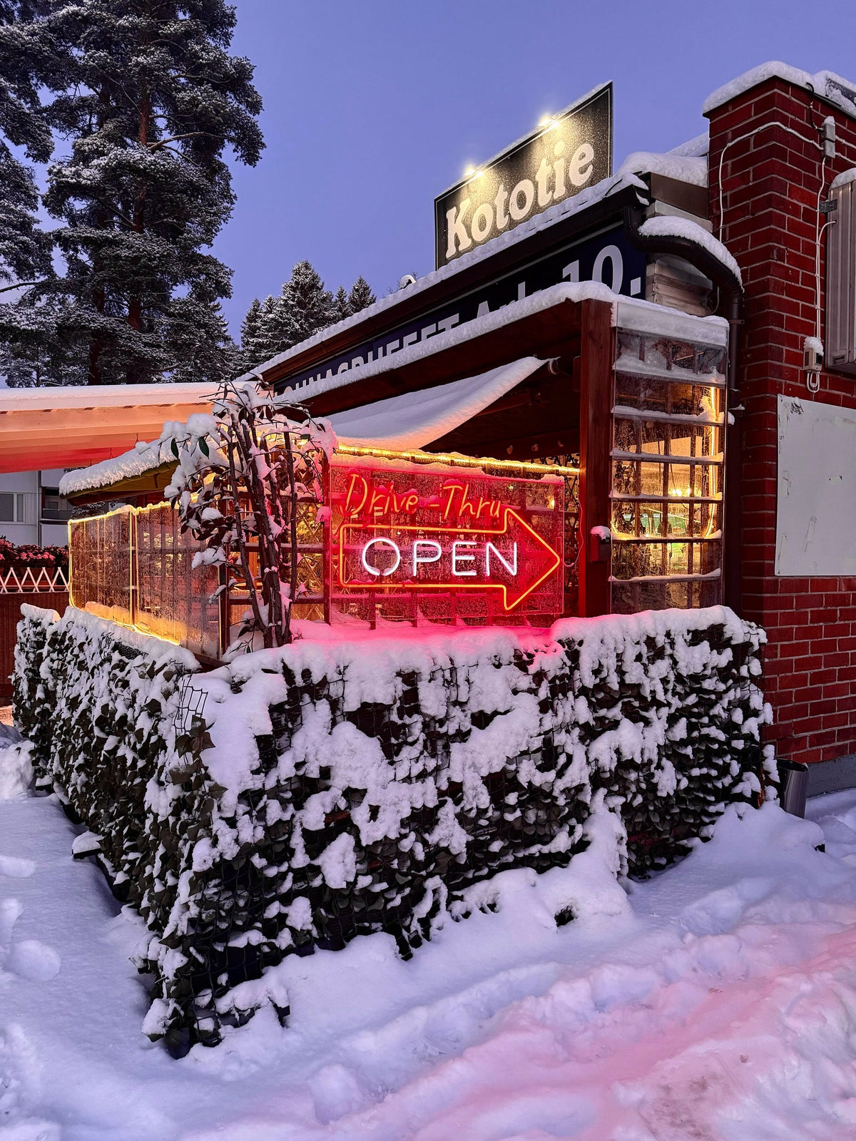 Červený venkovní LED neonový nápis Drive-Thru OPEN u restaurace Kototie v zasněženém Seinäjoki